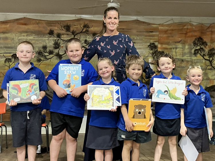 Photo of Teacher with students holding up awards received at Presentation Night