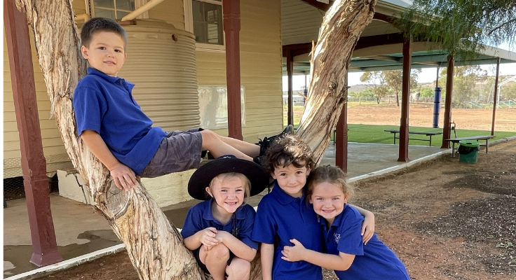 4 Students standing next to and in a tree at White Cliffs Public School