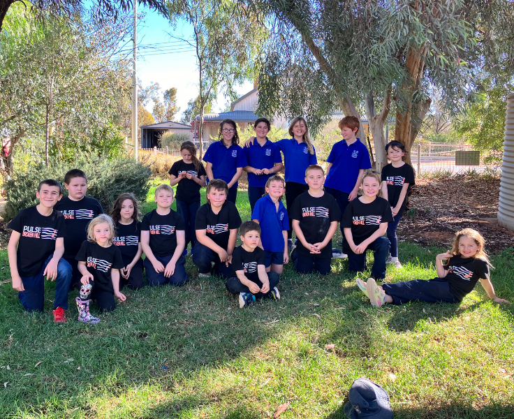 Students standing on lawn area wearing their Pulse T-Shirts