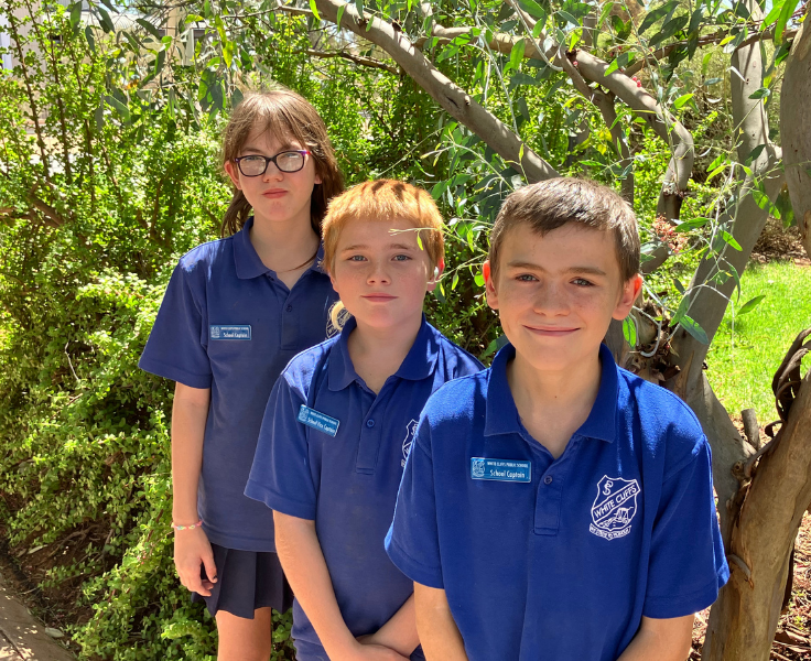 Photo of our school leaders who are standing in front of a garden